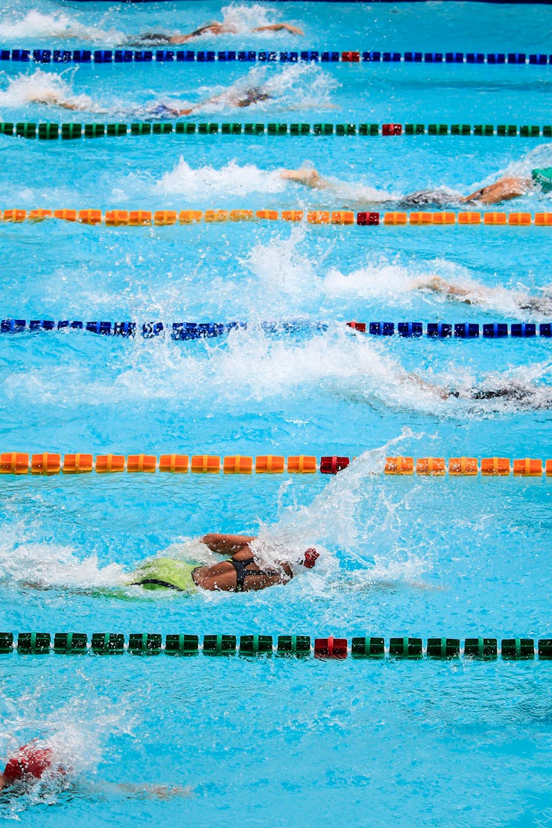 Swimmers compete in an outdoor pool race, showcasing athleticism and sportsmanship.